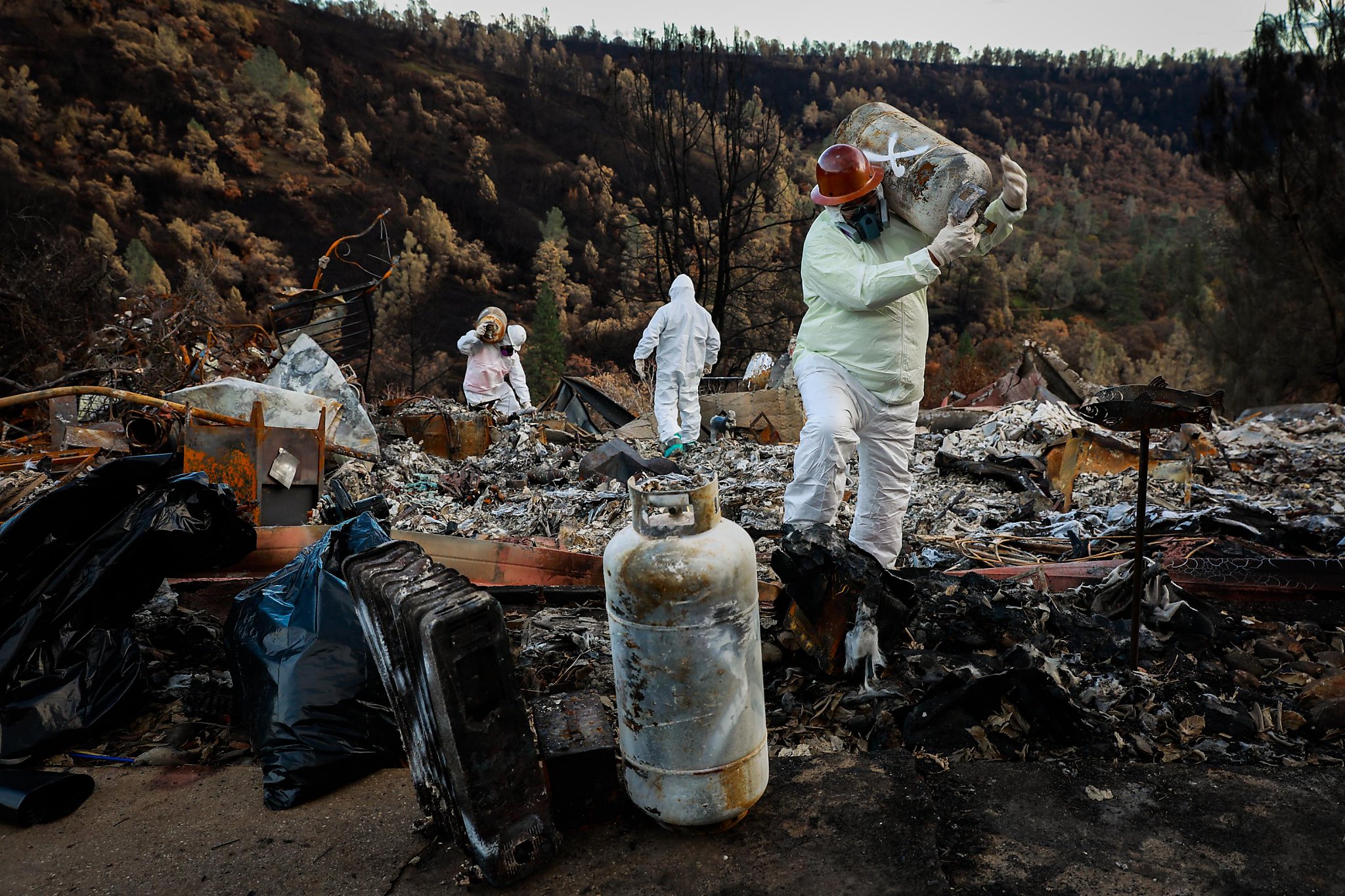 Fire cleanup crew in hazmat suites cleanup after a wildfire