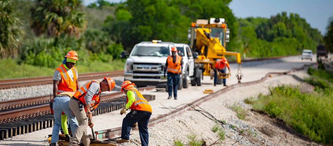 Construction crews position a rail