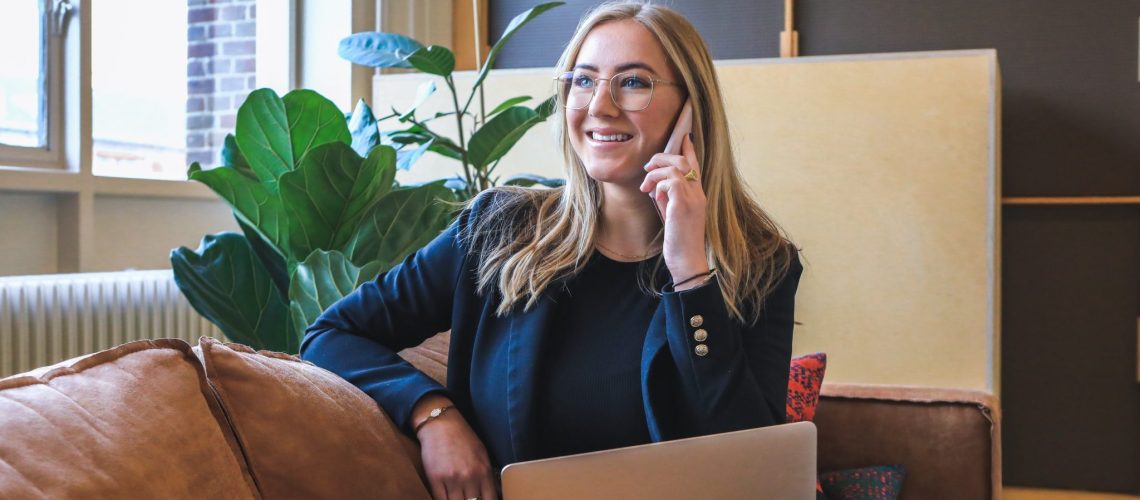 Engineering job search process: a smiling woman on the phone with an open laptop