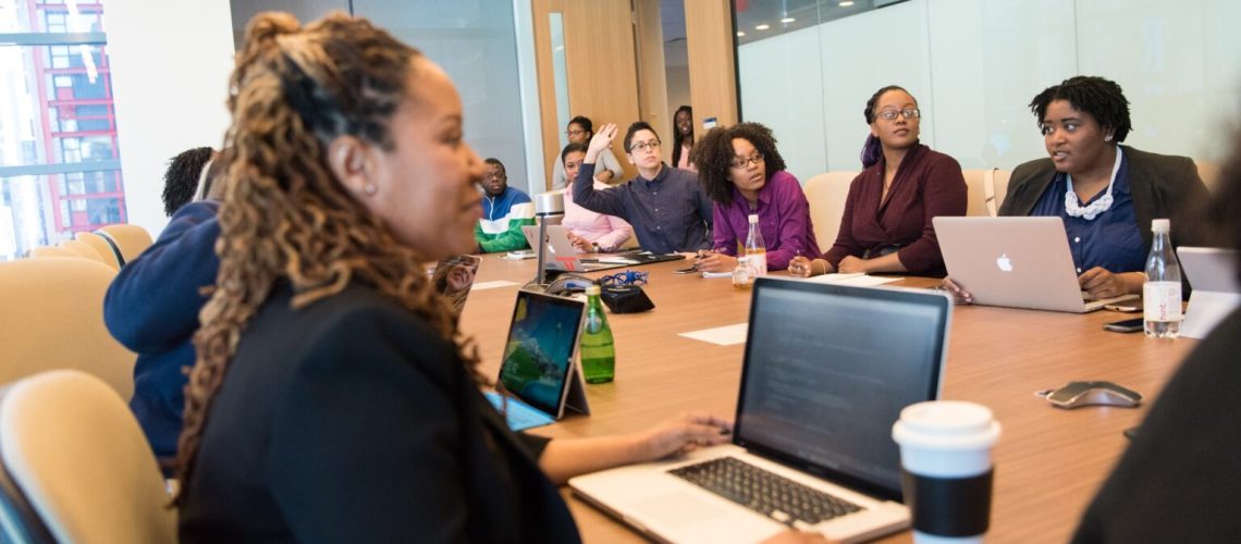Several people seated in an engineering staffing agency conference room.