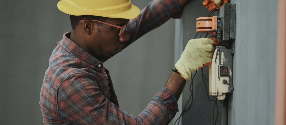 A man performing an electrical engineering job