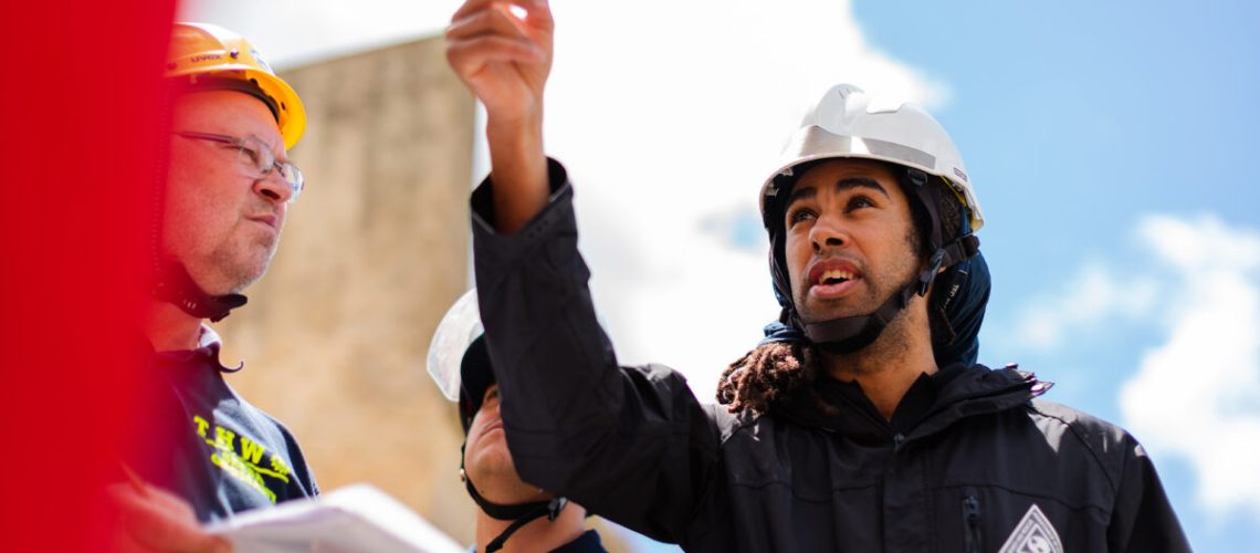 An engineer talking to his colleagues while pointing out something