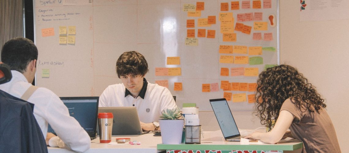 A team of professionals working on laptops