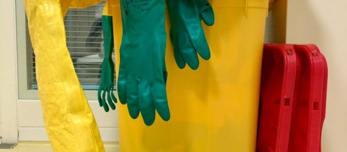 Hazardous waste cleaning protective gear in a trash can