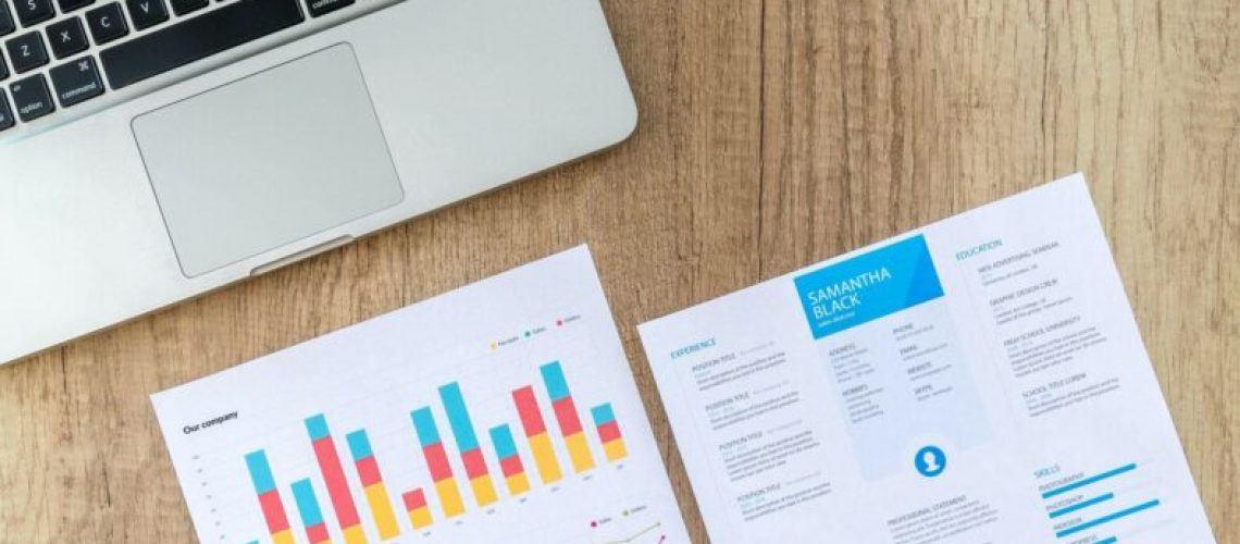 Copy of a resume and company documents on a brown surface