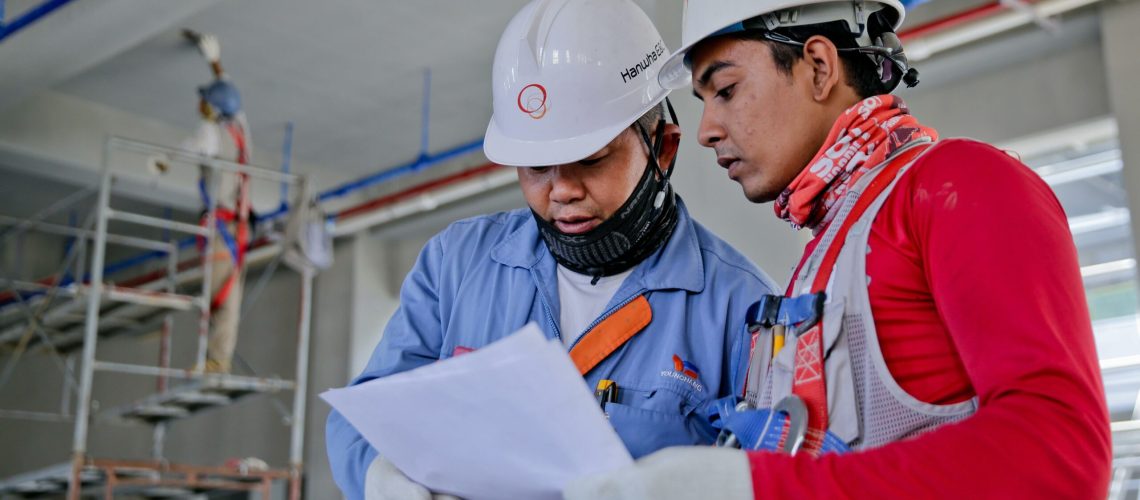 Two construction workers looking at papers